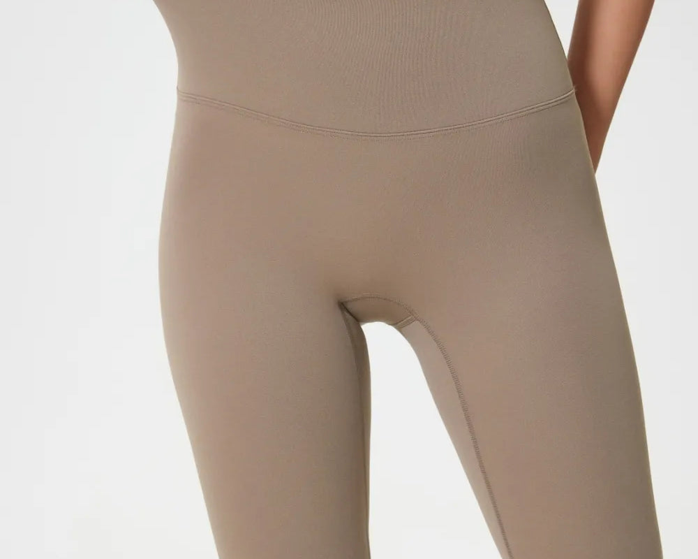Beige high-waisted shorts being modeled on a plain background