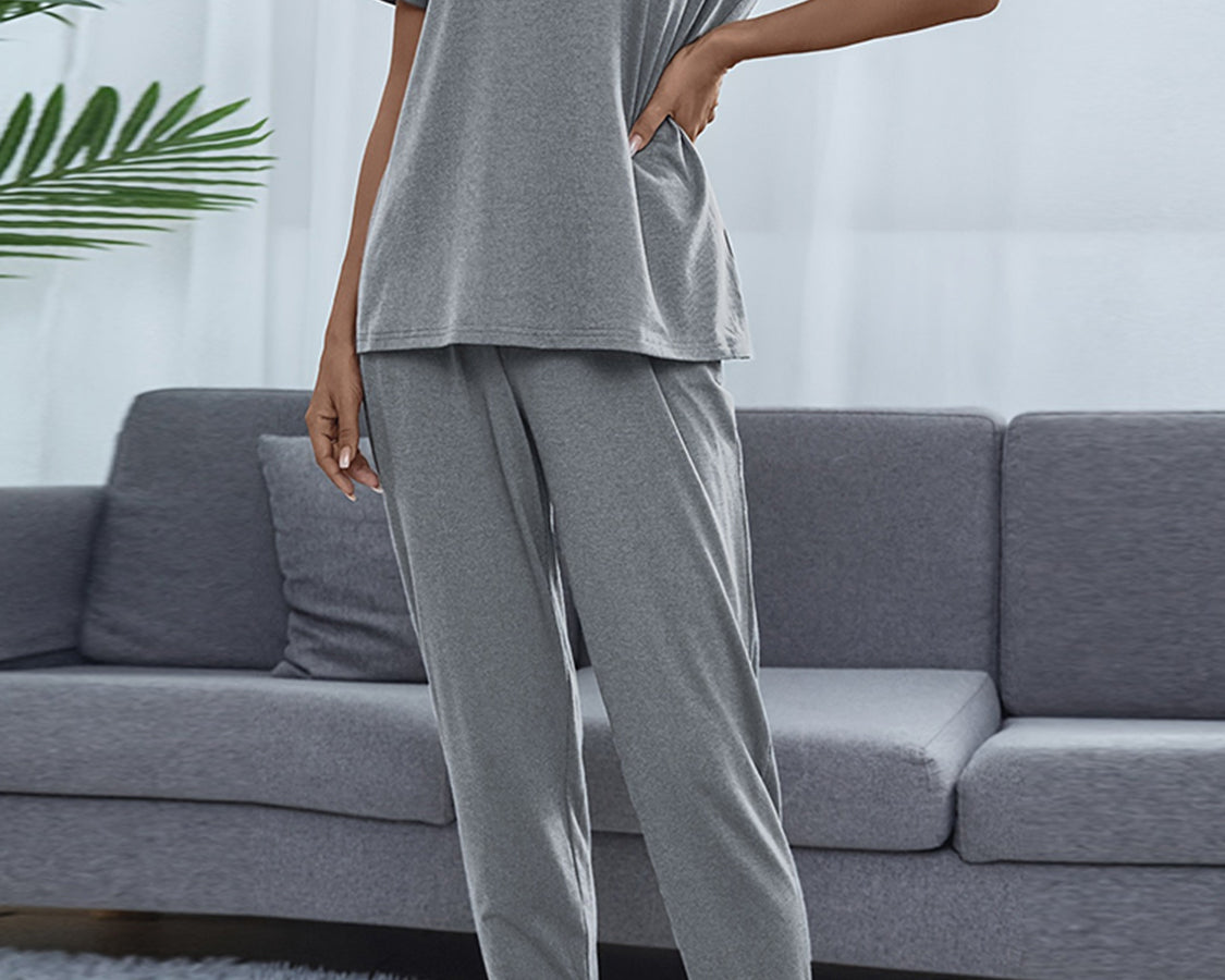 NEWYORKLISTED Intimate Apparel: Person wearing a gray pajama set in a living room setting.