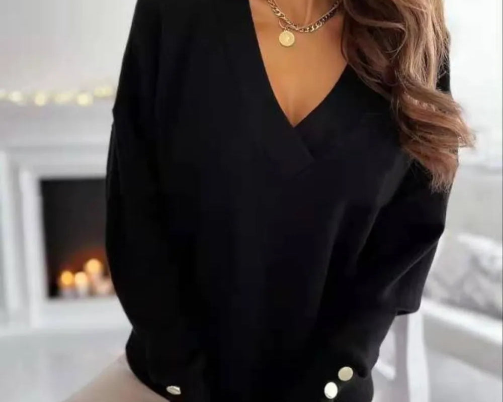 NEWYORKLISTED STYLE COLLECTION: Person wearing a black sweater with button details in a blurred indoor setting