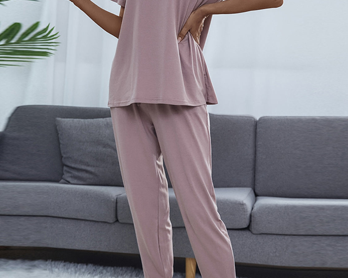 NEWYORKLISTED Intimate Apparel: Person wearing a pink pajama set in a living room setting.