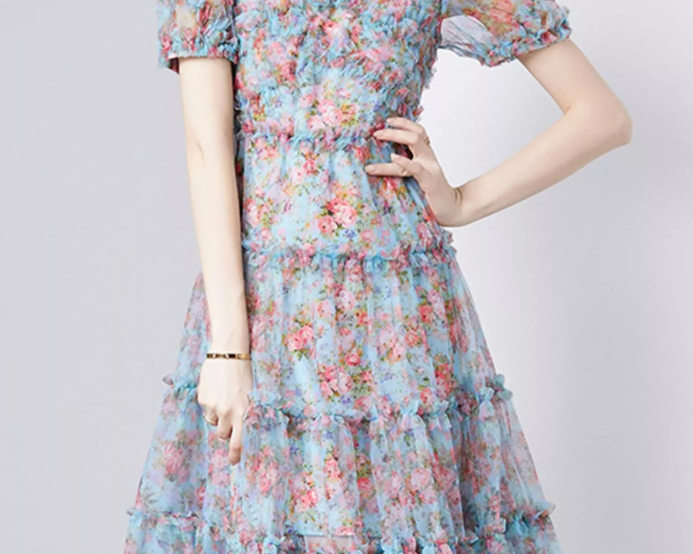 NEWYORKLISTED STYLE COLLECTION: Woman wearing a floral dress on a plain background