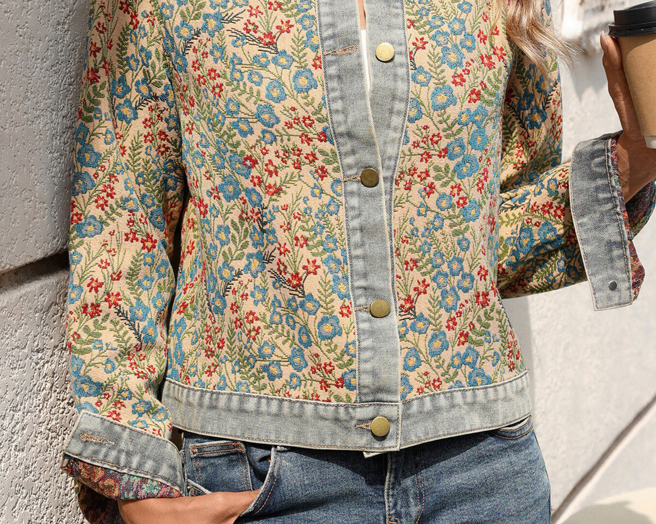 NEWYORKLISTED STYLE COLLECTION: Person wearing a floral denim jacket and jeans, holding a coffee cup.