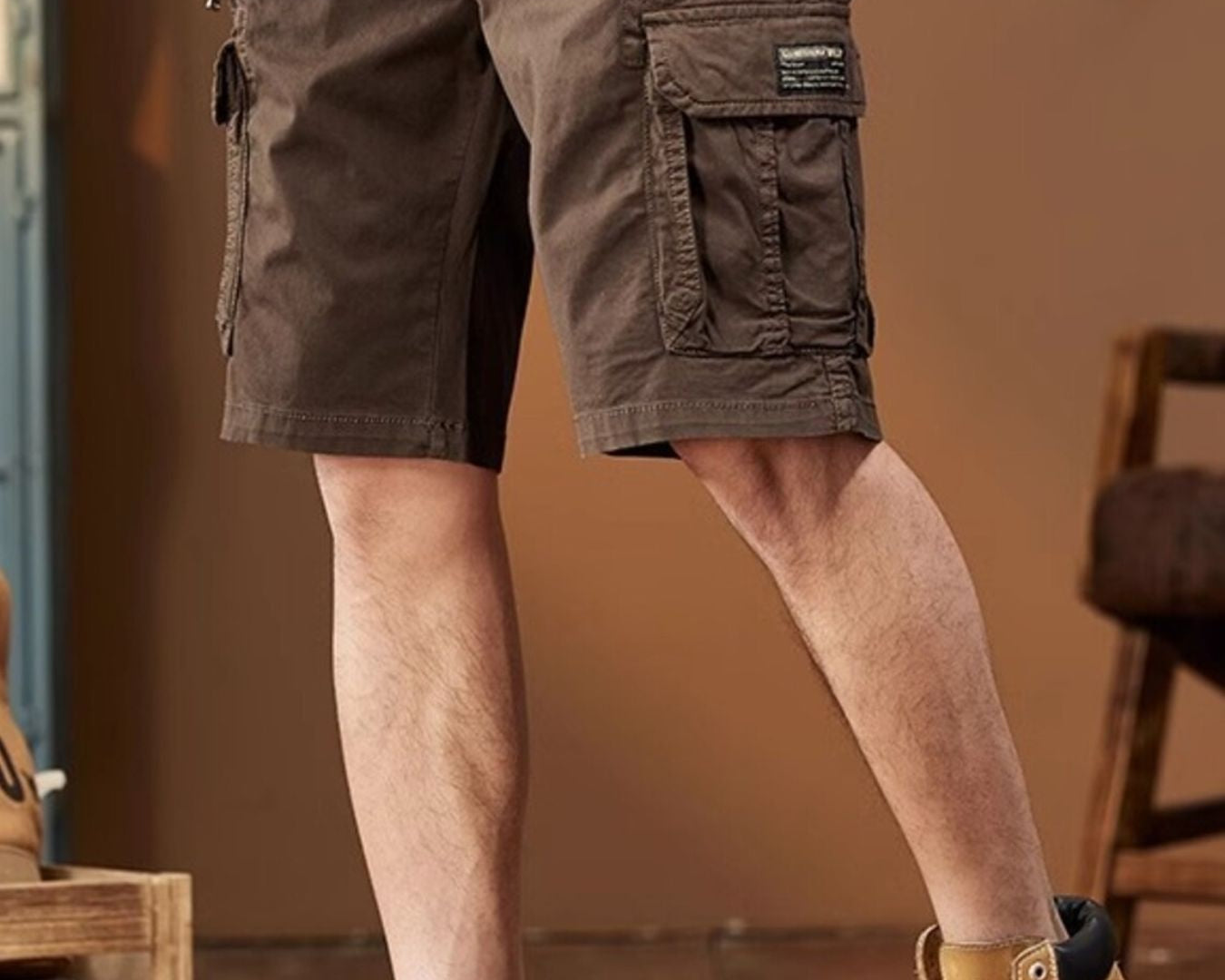 NEWYORKLISTED ATLAS MEN's COLLECTION: Person wearing brown cargo shorts and yellow boots indoors.