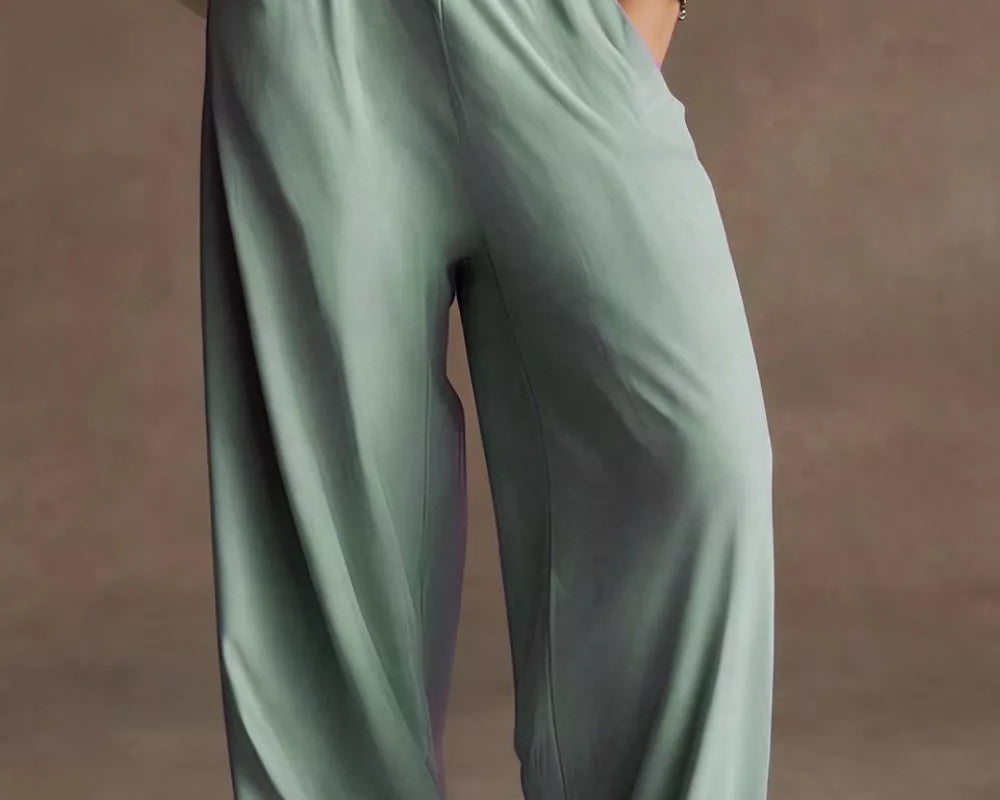 NEWYORKLISTED STYLE COLLECTION: Person wearing light green pants and a beige jacket on a brown background