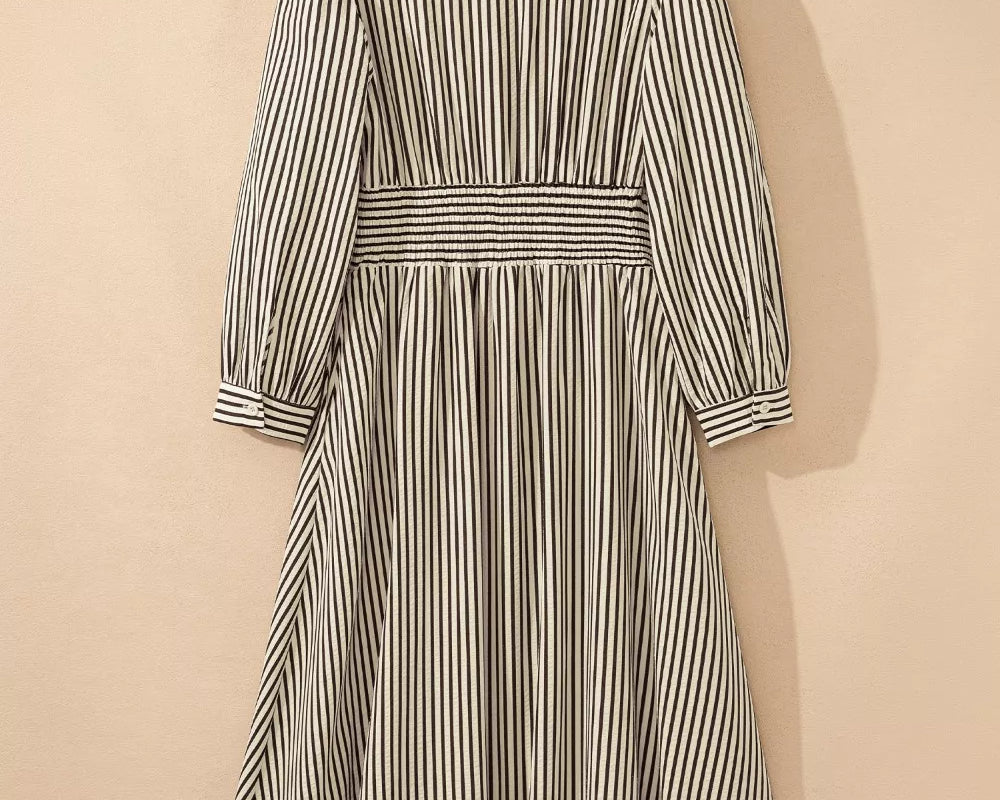 NEWYORKLISTED STYLE COLLECTION: Striped dress on a hanger against a beige background