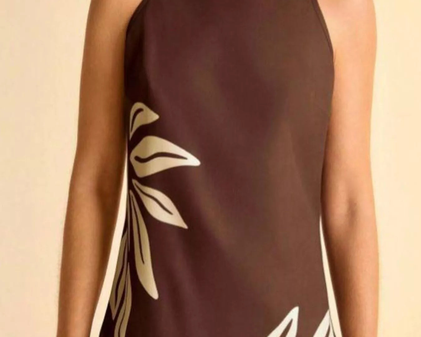 NEWYORKLISTED STYLE COLLECTION: Brown dress with white leaf patterns worn by a person on a beige background