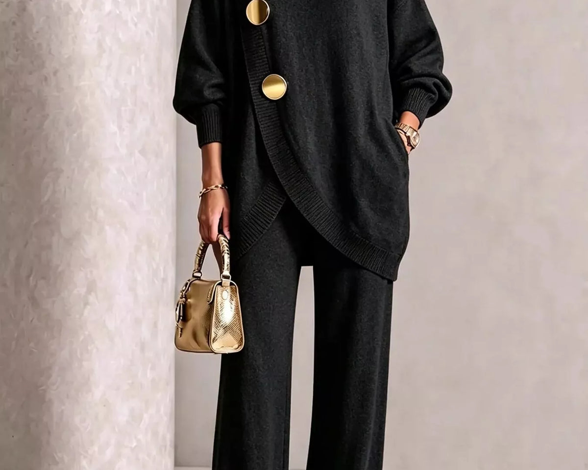 NEWYORKLISTED STYLE COLLECTION: A model wearing a black knit turtleneck sweater with oversized sleeves and three prominent gold buttons, paired with black wide-leg trousers and holding a small metallic gold handbag.