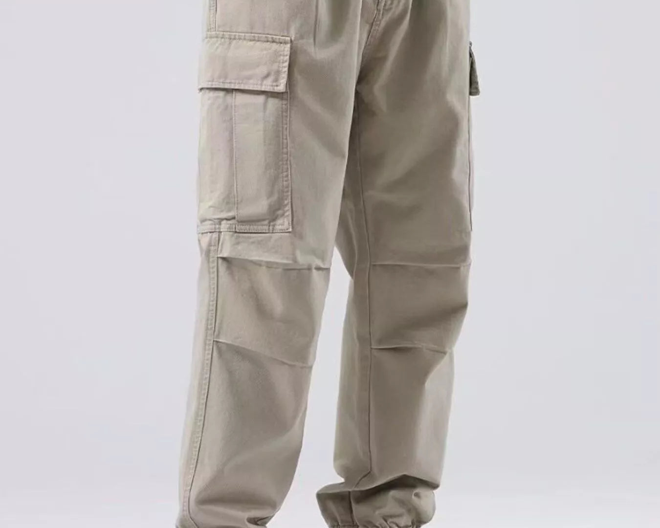 NEWYORKLISTED ATLAS MEN'S COLLECTION: Person wearing beige cargo pants and black high-top sneakers on a white background