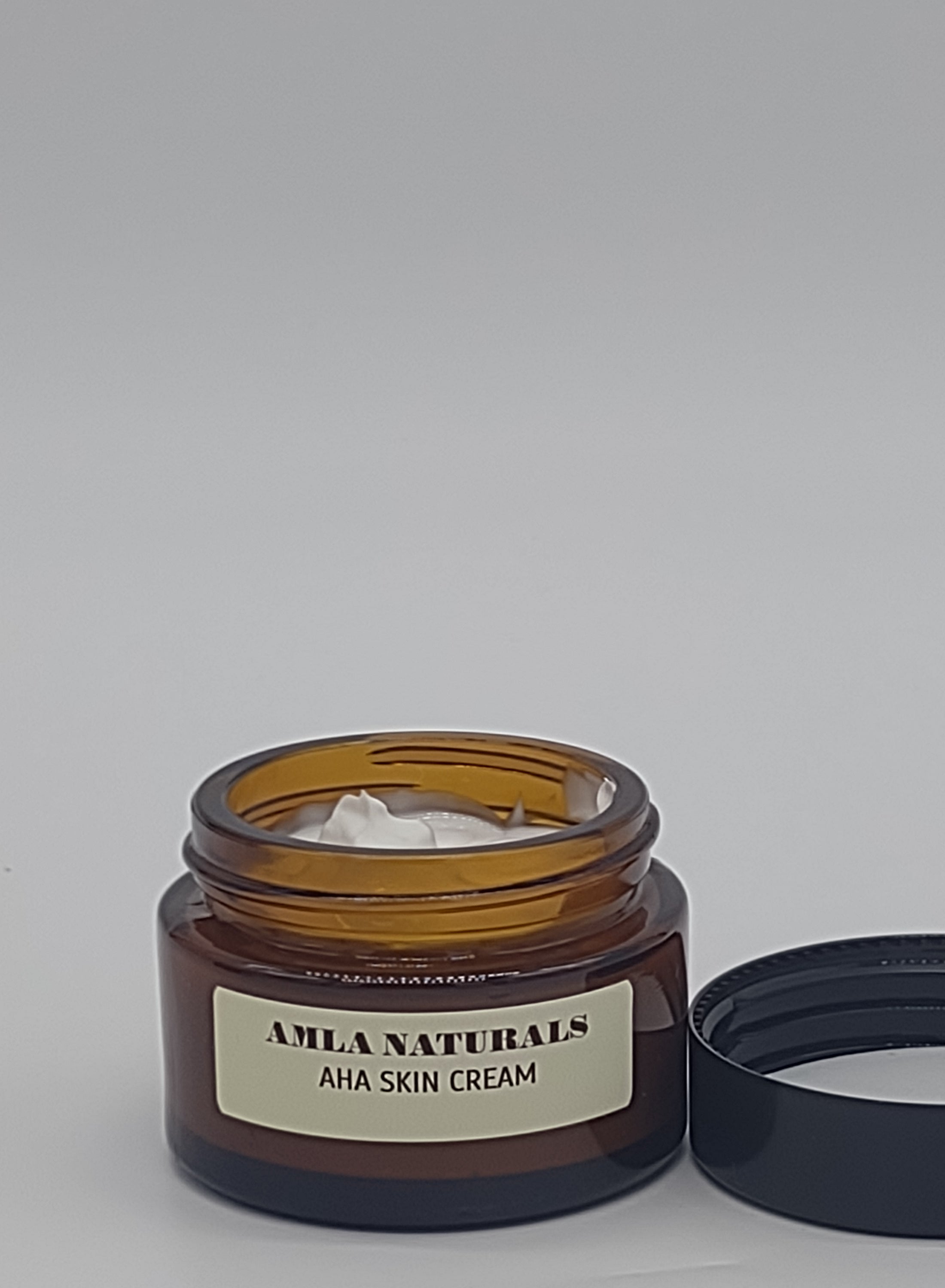 AMLA NATURALS AHA Skin Cream: Jar of AHA skin cream with a black lid on a light gray background