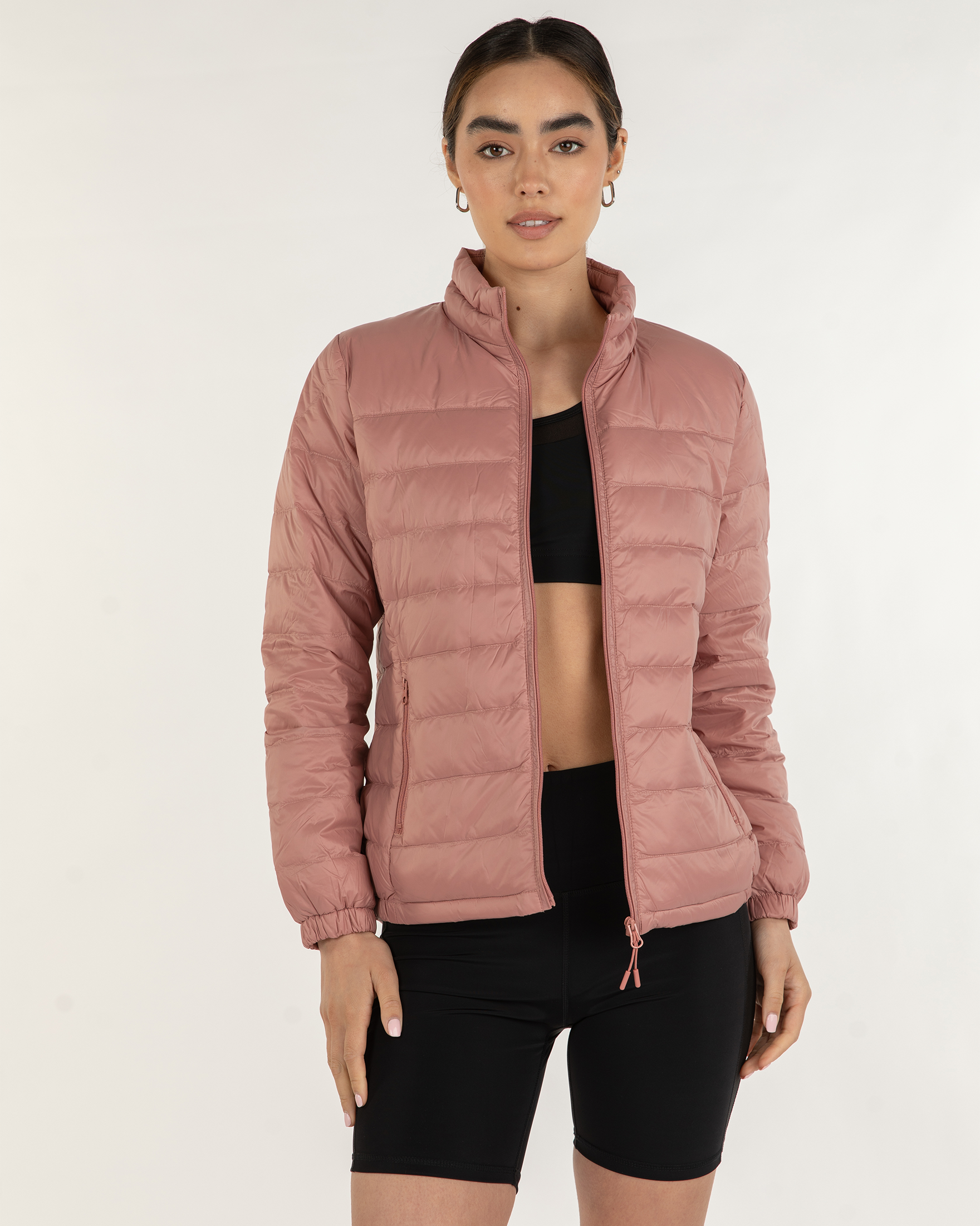 NEWYORKLISTED STYLE COLLECTION: Person wearing a pink puffer jacket on a white background in rose