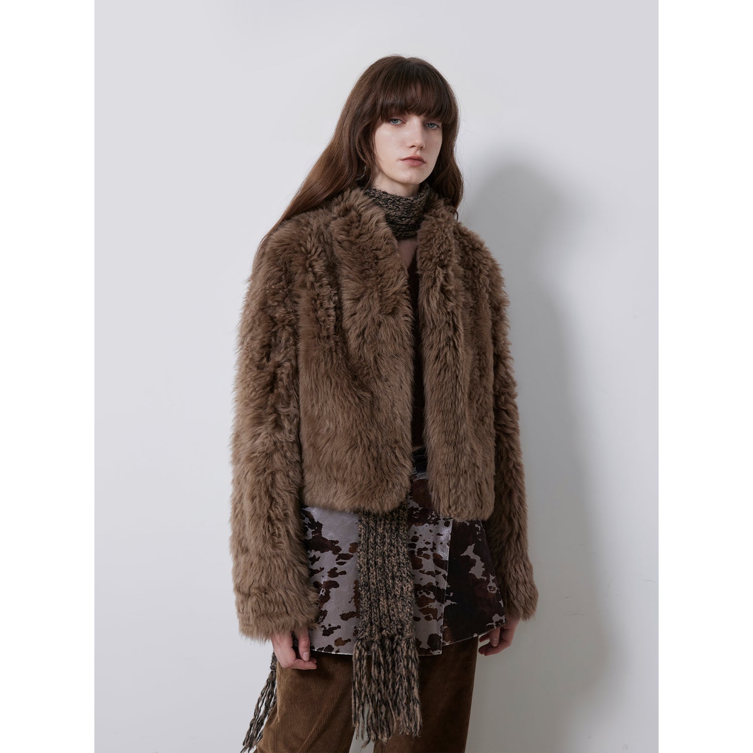 NEWYORKLISTED STYLE COLLECTION: Woman wearing a brown fur coat with a plain background