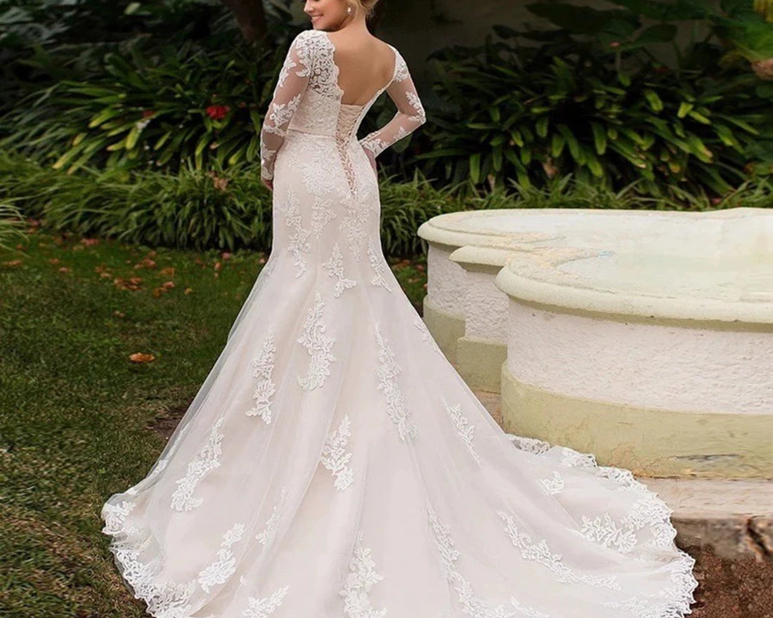 Woman wearing a white lace wedding dress in an outdoor setting.