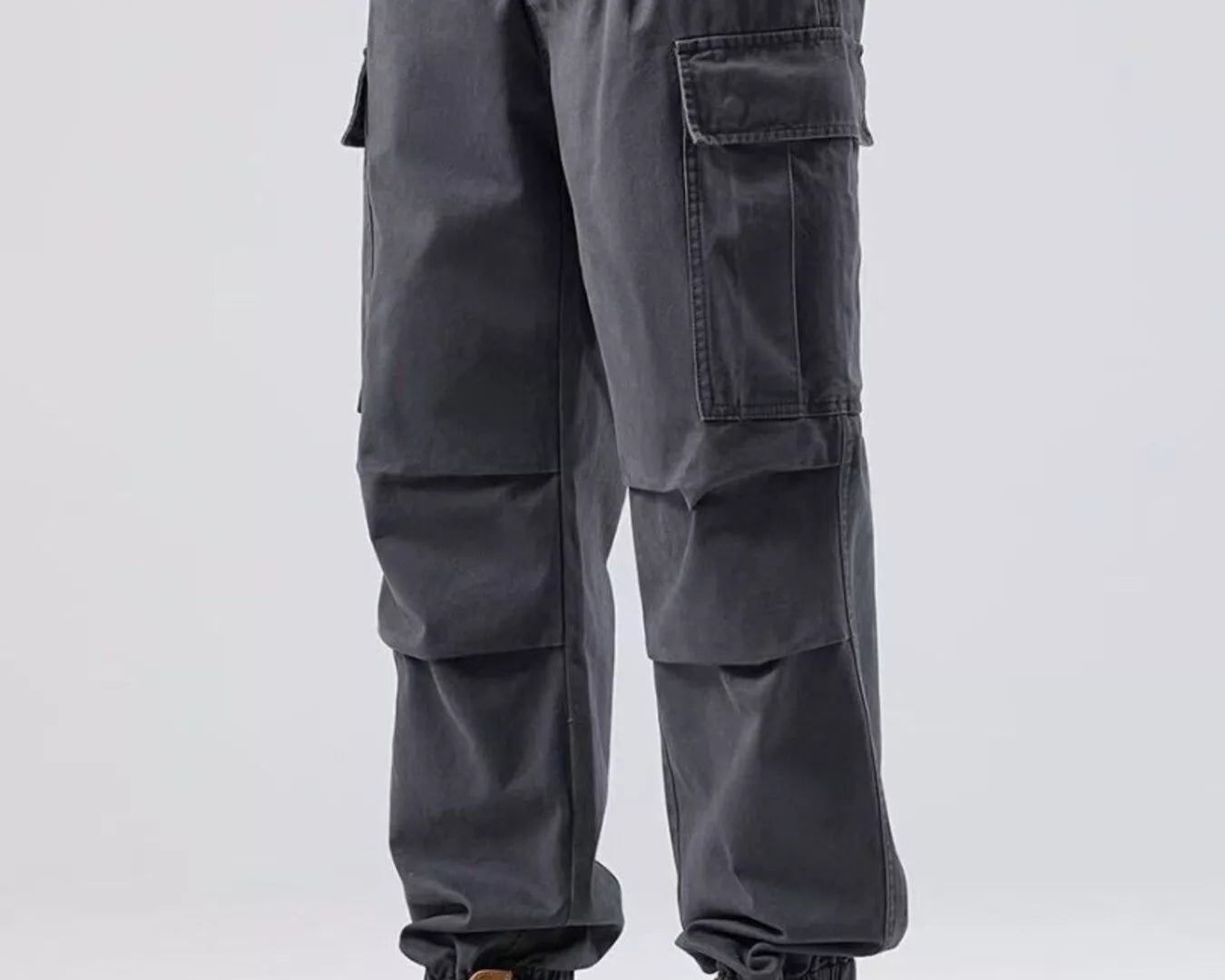 NEWYORKLISTED ATLAS MEN'S COLLECTION: Person wearing gray cargo pants and tan boots on a white background