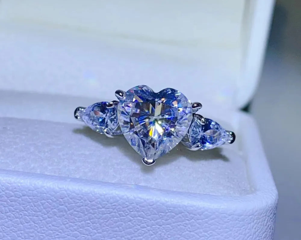 NYLD Glamour Collection By NEWYORKLISTED: Heart-shaped diamond ring with two pear-shaped diamonds on a white background
