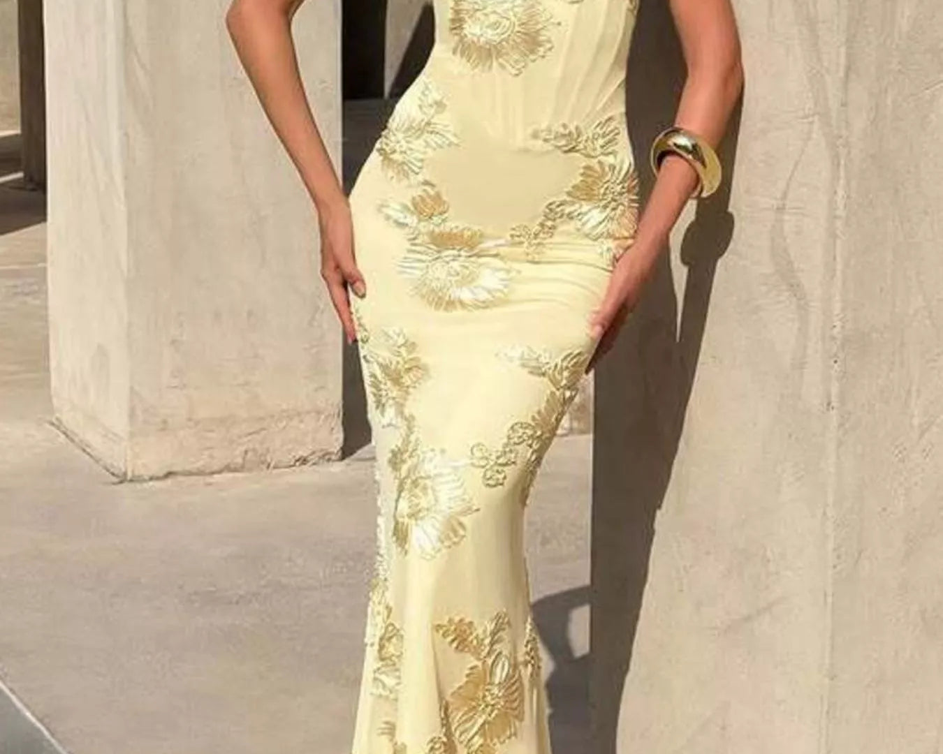 NEWYORKLISTED STYLE COLLECTION: Woman wearing a light yellow evening gown with floral embroidery against a neutral background