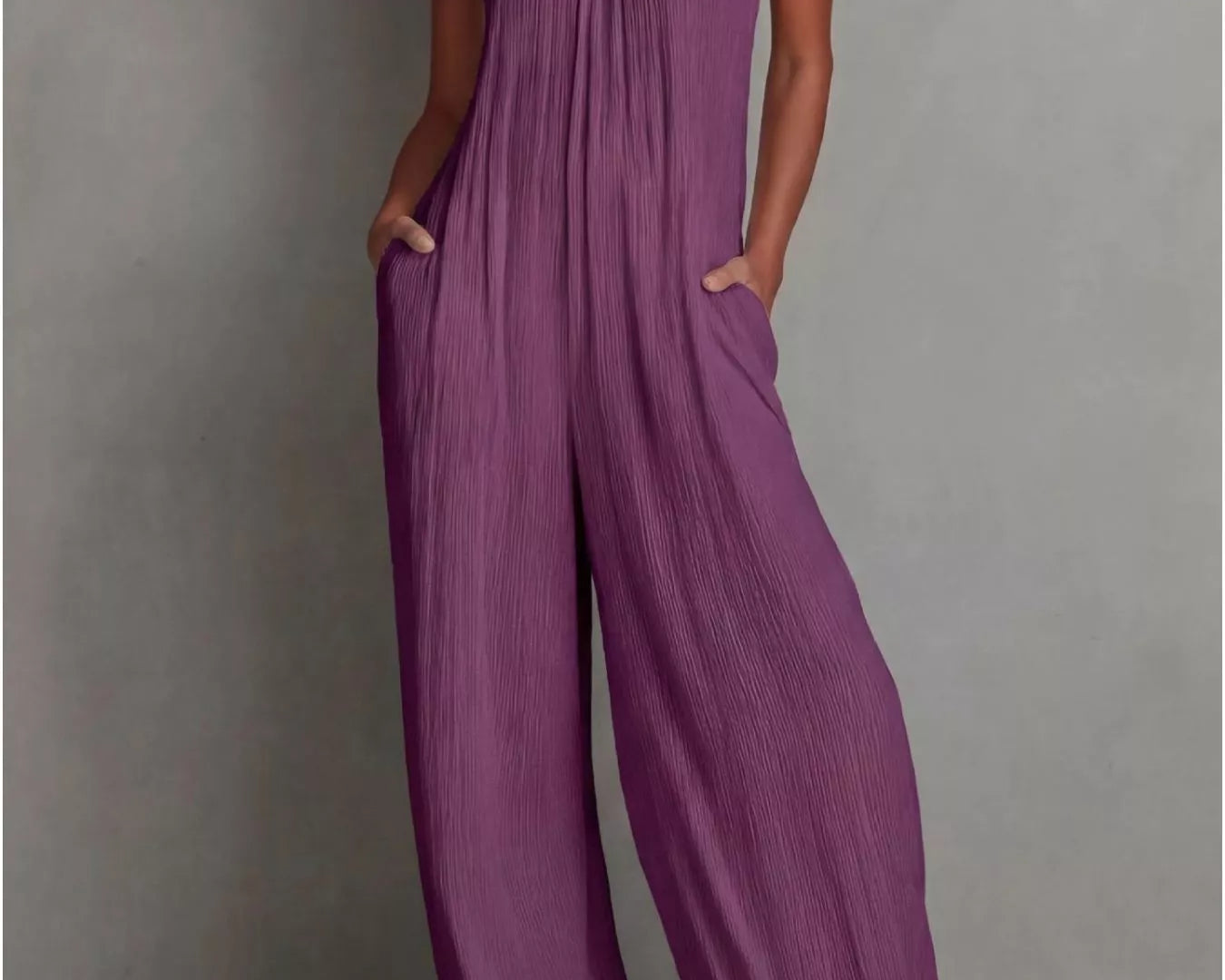 NEWYORKLISTED STYLE COLLECTION: Woman wearing a purple jumpsuit against a gray background