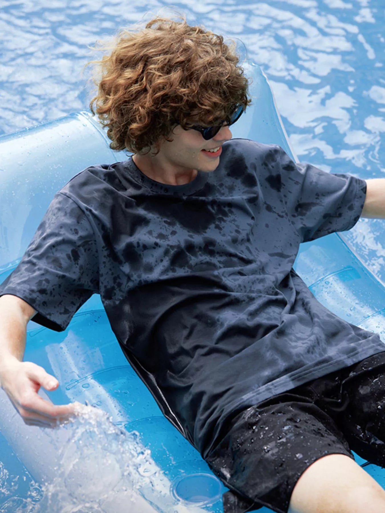 NEWYORKLISTED ATLAS MEN's COLLECTION: Person lounging on an inflatable pool float in a pool