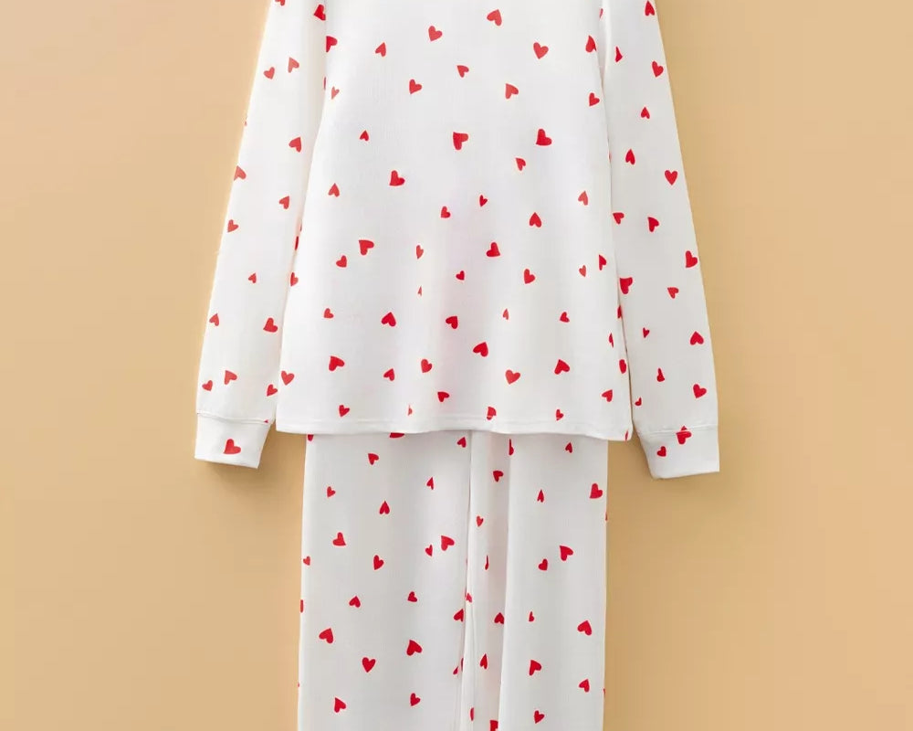 NEWYORKLISTED Intimate Apparel Collection: White pajama set with red heart patterns on a beige background