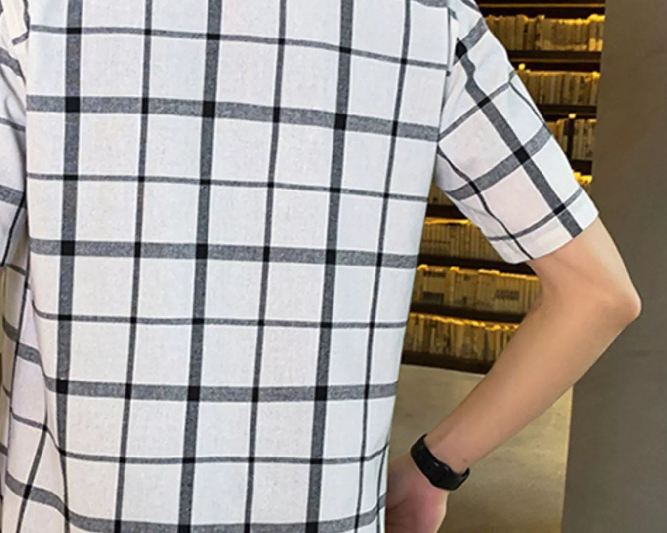NEWYORKLISTED ATLAS MEN'S COLLECTION: Person wearing a white and black checkered shirt in an indoor setting.