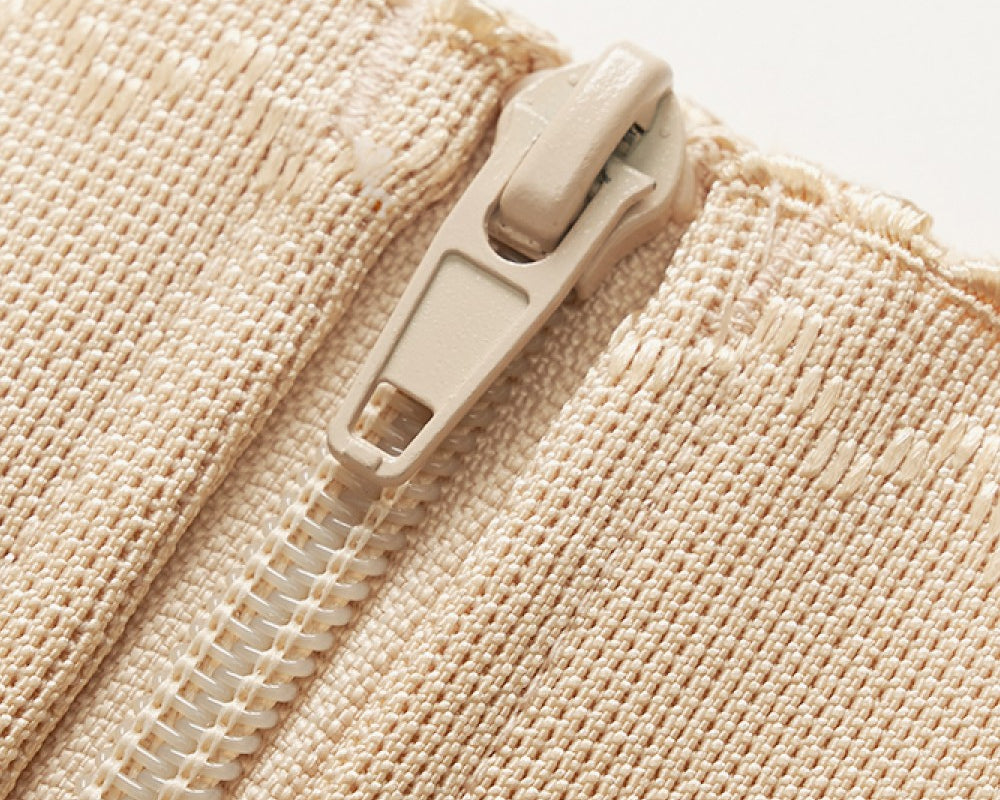 NEWYORKLISTED Intimate Apparel: Close-up of a beige zipper on a textured fabric background