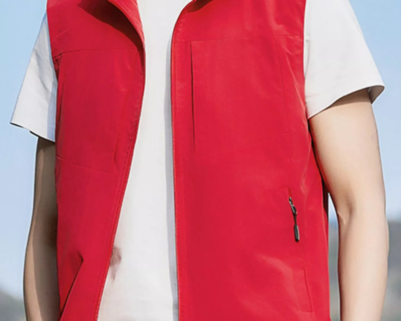 NEWYORKLISTED ATLAS MEN's COLLECTION: Person wearing a red vest over a white shirt with a blurred background