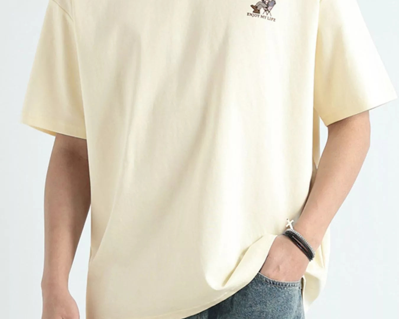 NEWYORKLISTED ATLAS MEN'S COLLECTION: Person wearing a beige t-shirt with a small logo on a plain background