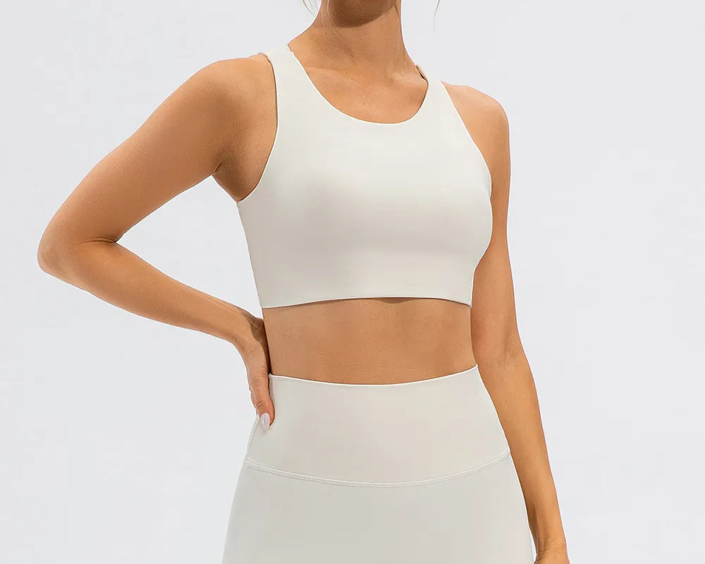 NEWYORKLISTED ACTIVEWEAR COLLECTION: Woman wearing a white athletic outfit on a light gray background