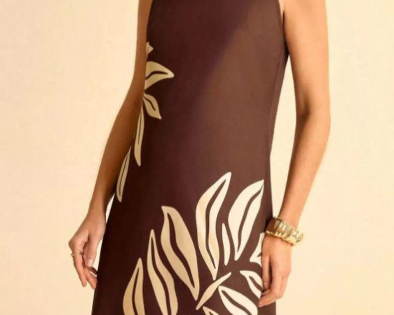 NEWYORKLISTED STYLE COLLECTION: Woman wearing a brown dress with white leaf patterns on a beige background