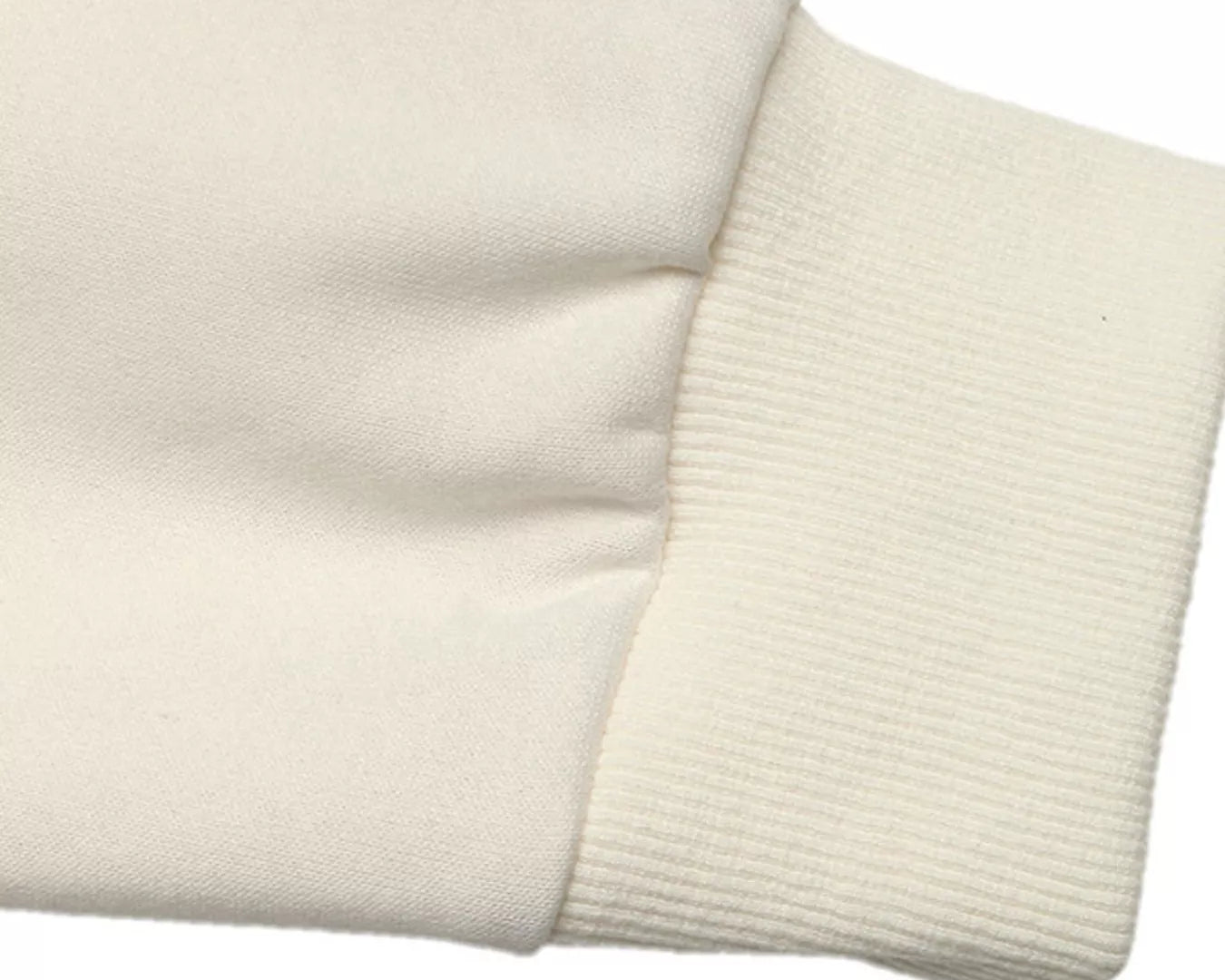 NEWYORKLISTED STYLE COLLECTION: Close-up of a beige sweater sleeve on a white background
