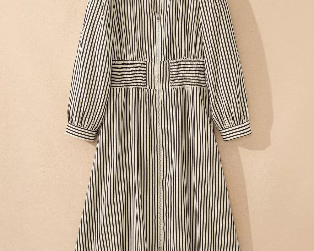NEWYORKLISTED STYLE COLLECTION: Striped dress on a hanger against a beige background
