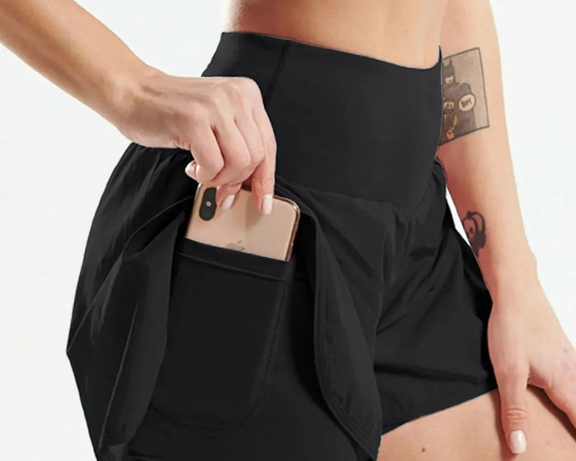 NEWYORKLISTED Activewear: Person wearing black athletic shorts with a pocket, holding a phone.