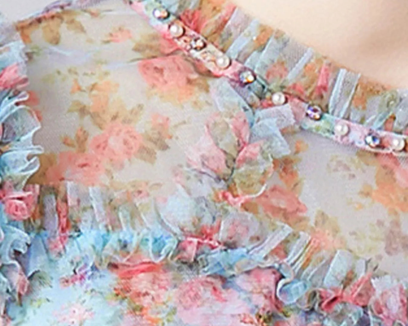 NEWYORKLISTED STYLE COLLECTION: Floral dress with ruffled details and pearl embellishments on a blurred background