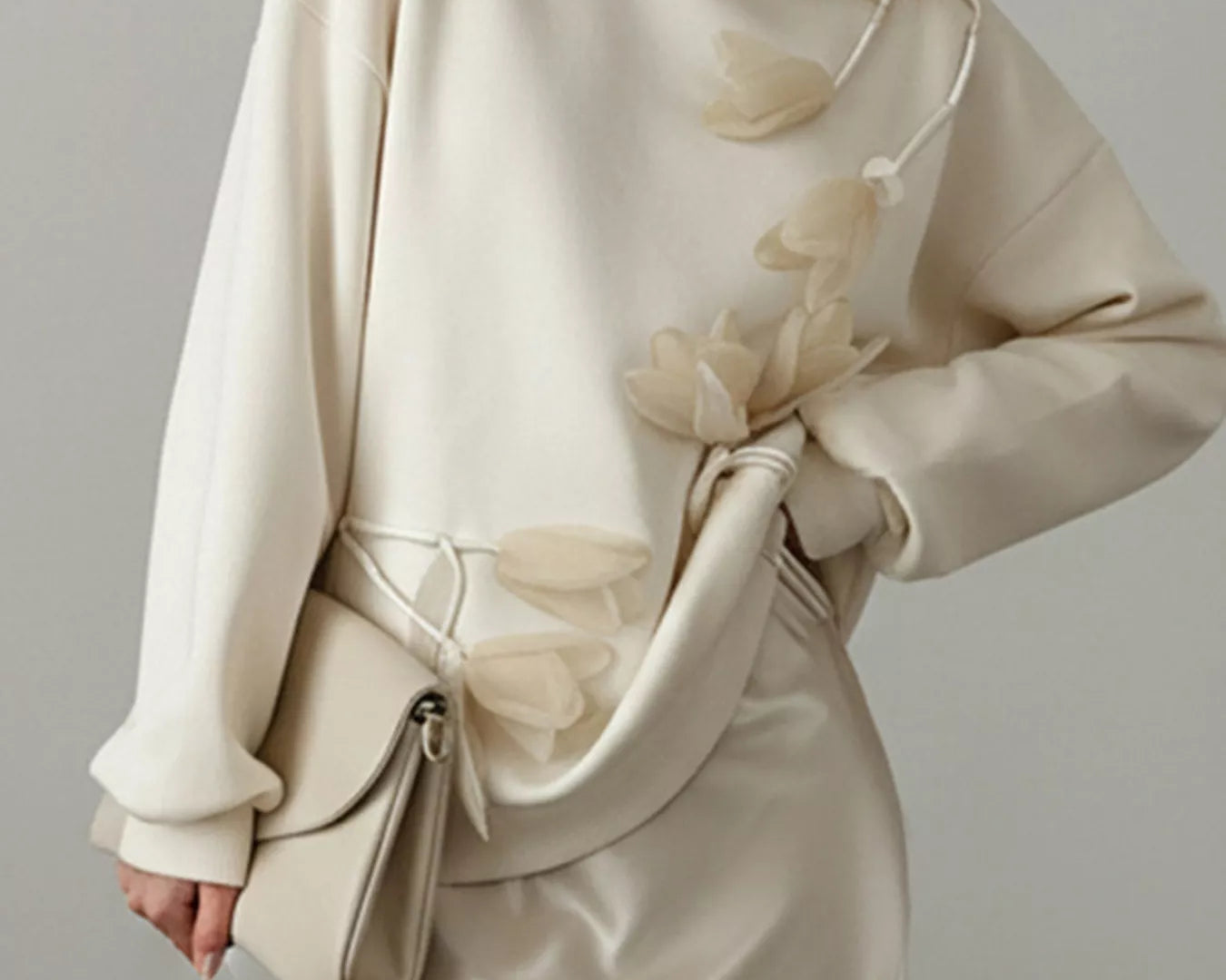 NEWYORKLISTED STYLE COLLECTION: Woman wearing a beige outfit with a matching handbag against a neutral background