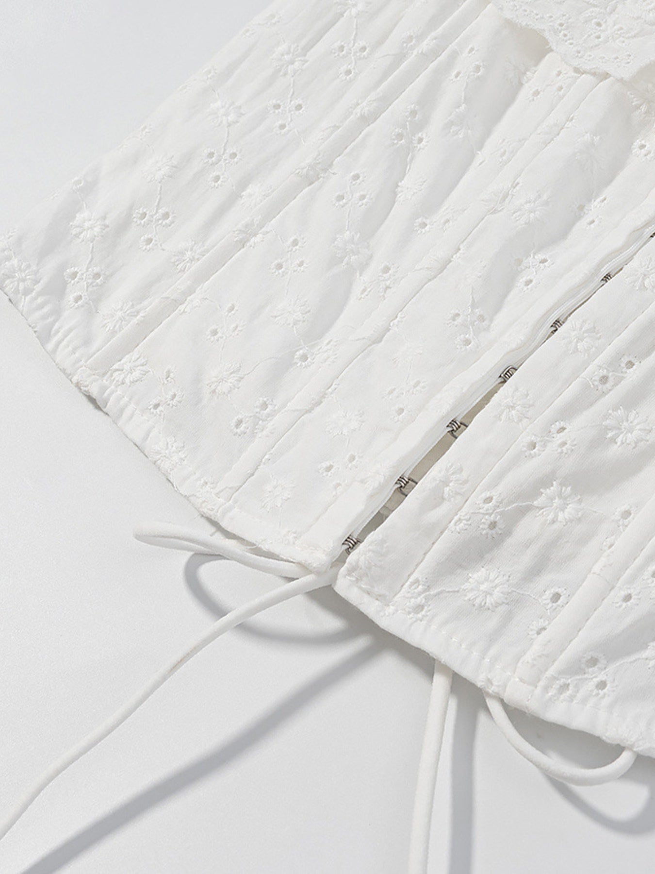 NEWYORKLISTED STYLE COLLECTION: Close-up of a textured white fabric with a zipper on a light gray background