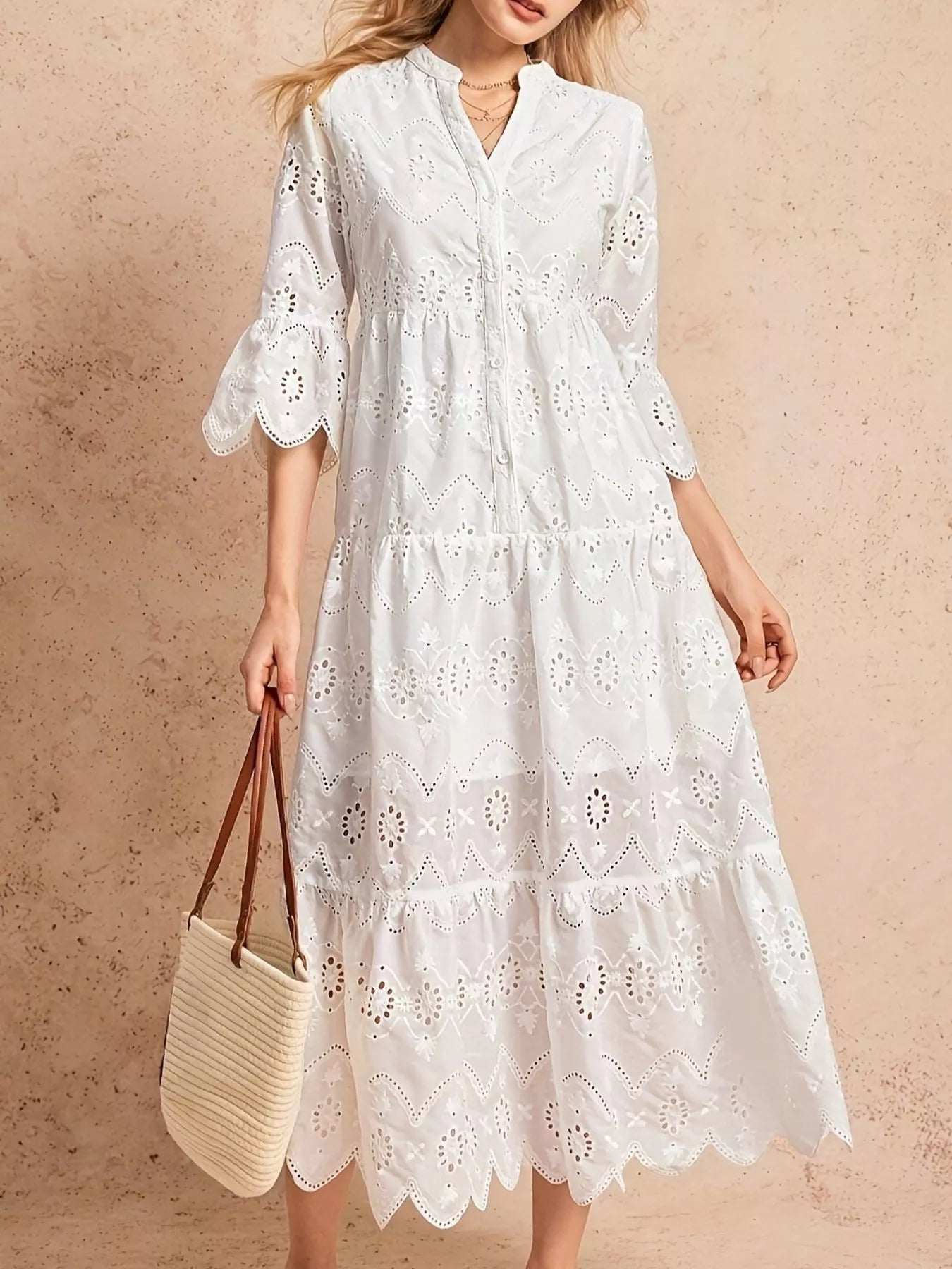 NEWYORKLISTED STYLE COLLECTION: Woman wearing a white lace dress holding a straw bag against a beige background