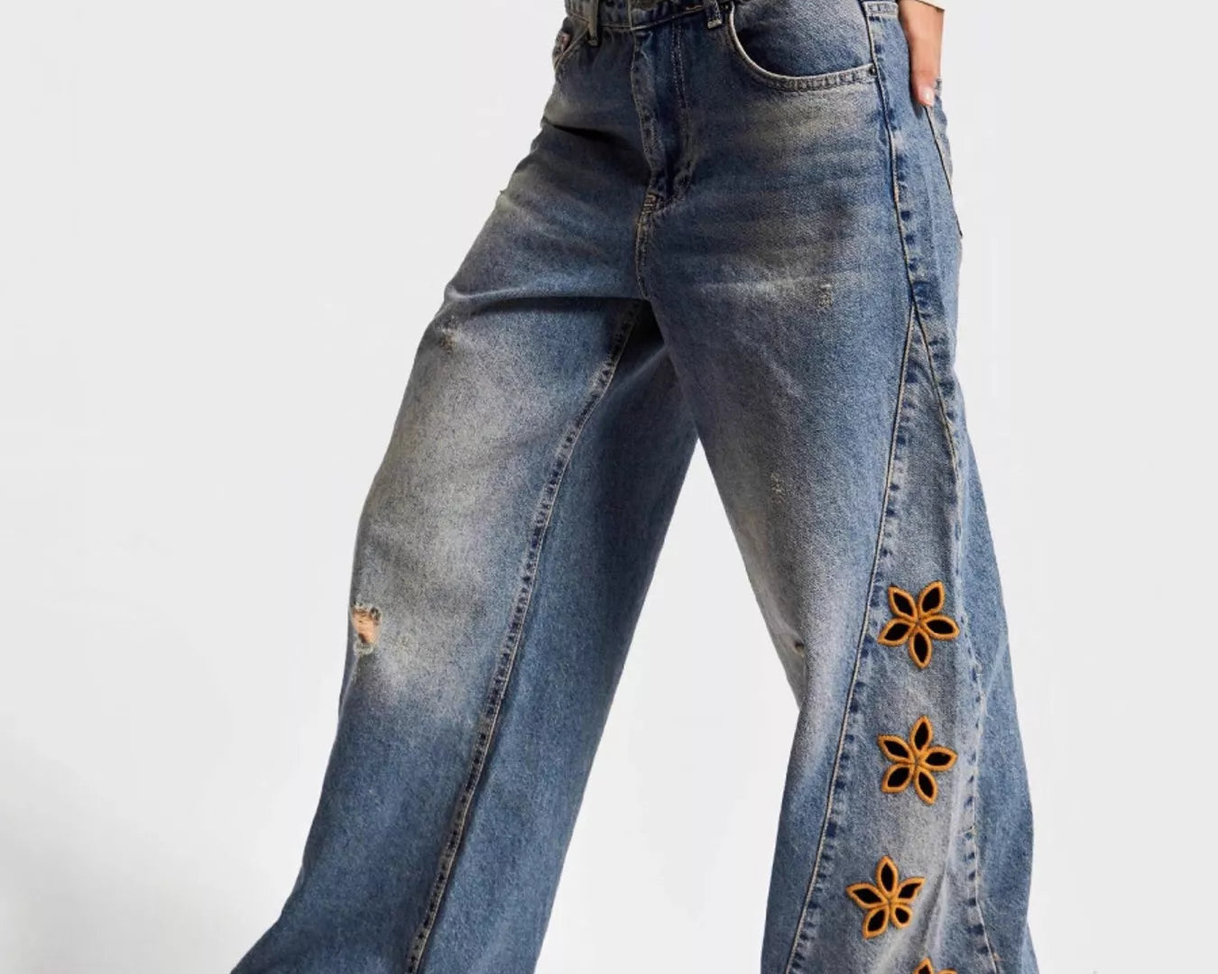 NEWYORKLISTED STYLE COLLECTION: Wide-leg jeans with floral embellishments on a white background