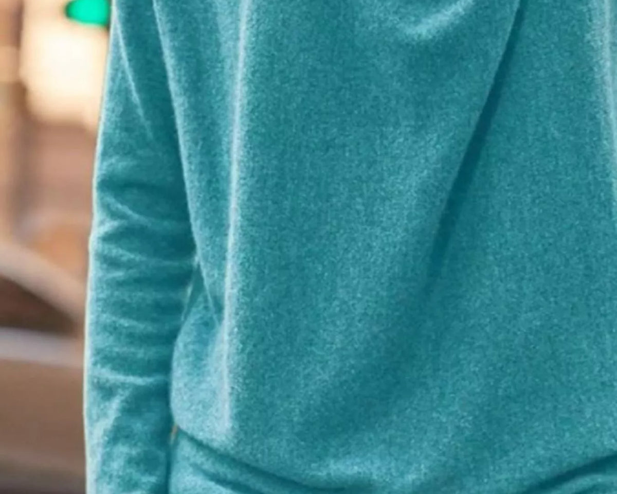 NEWYORKLISTED STYLE COLLECTION: Teal hoodie worn by a person with a blurred background
