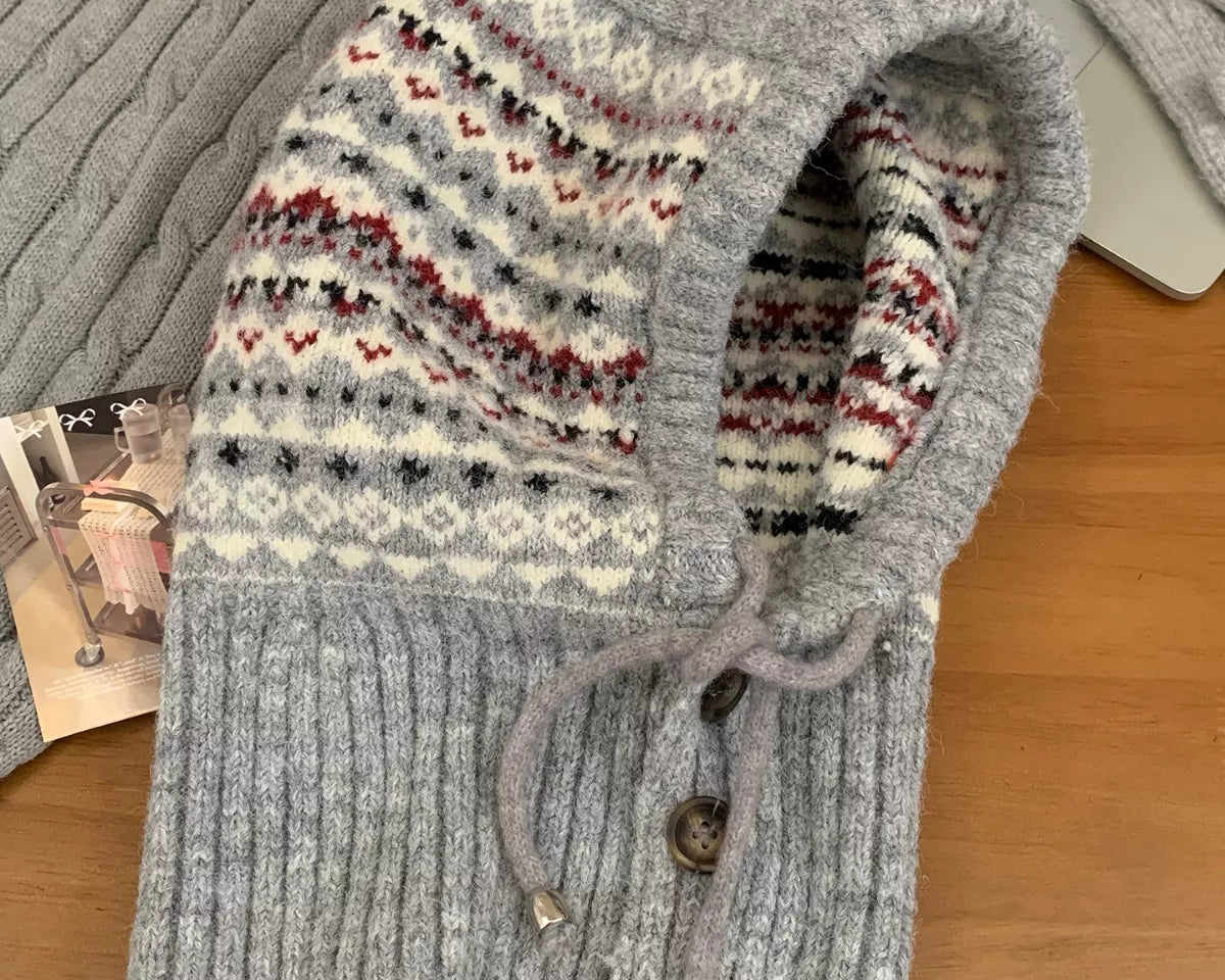 NEWYORKLISTED STYLE COLLECTION: Drawstring Knitted Winter Hat – Cozy, Chic & Cold-Weather Ready Gray knitted hoodie with patterned hood on a wooden surface