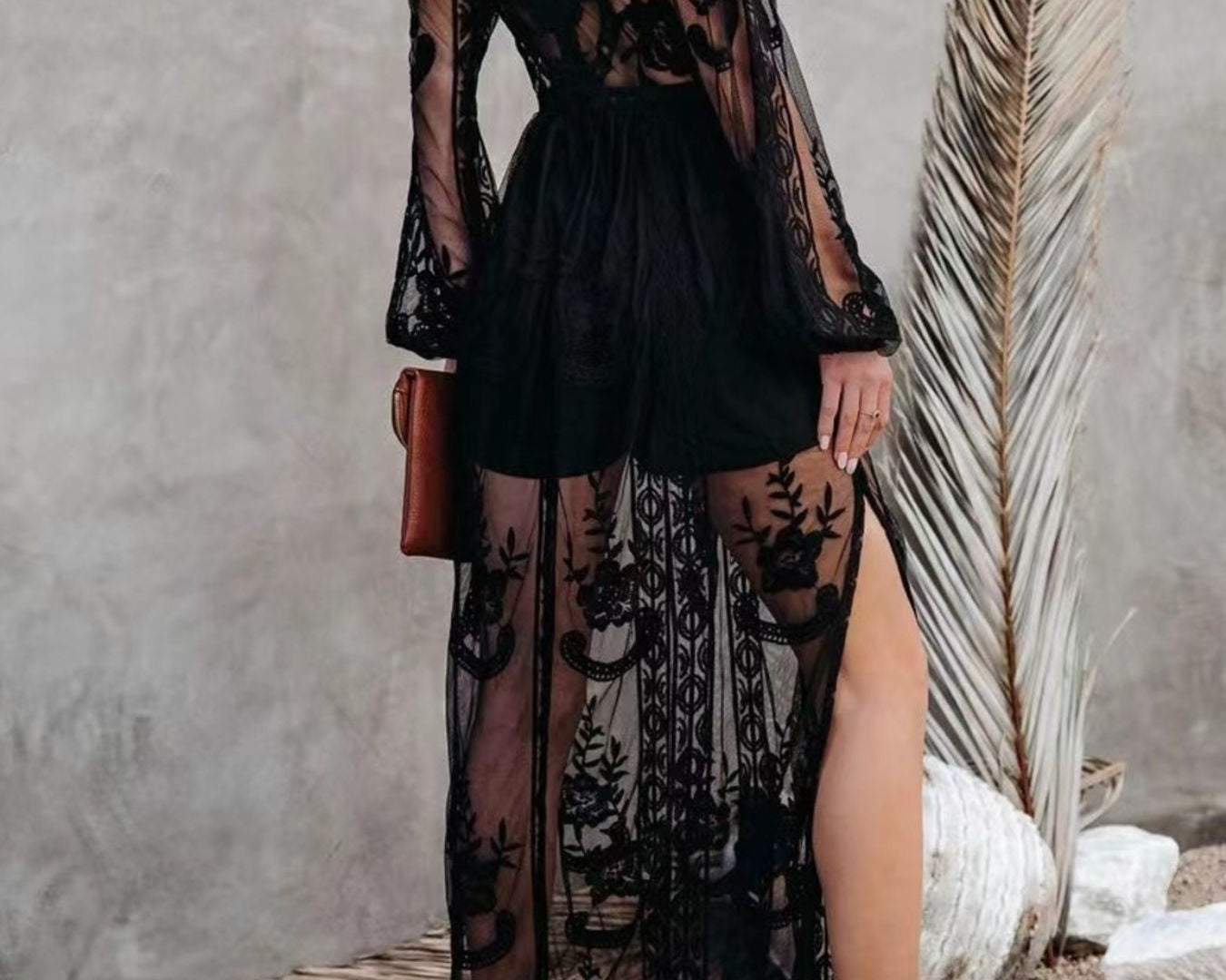 NEWYORKLISTED STYLE COLLECTION: Woman wearing a black lace dress with sheer panels against a neutral background