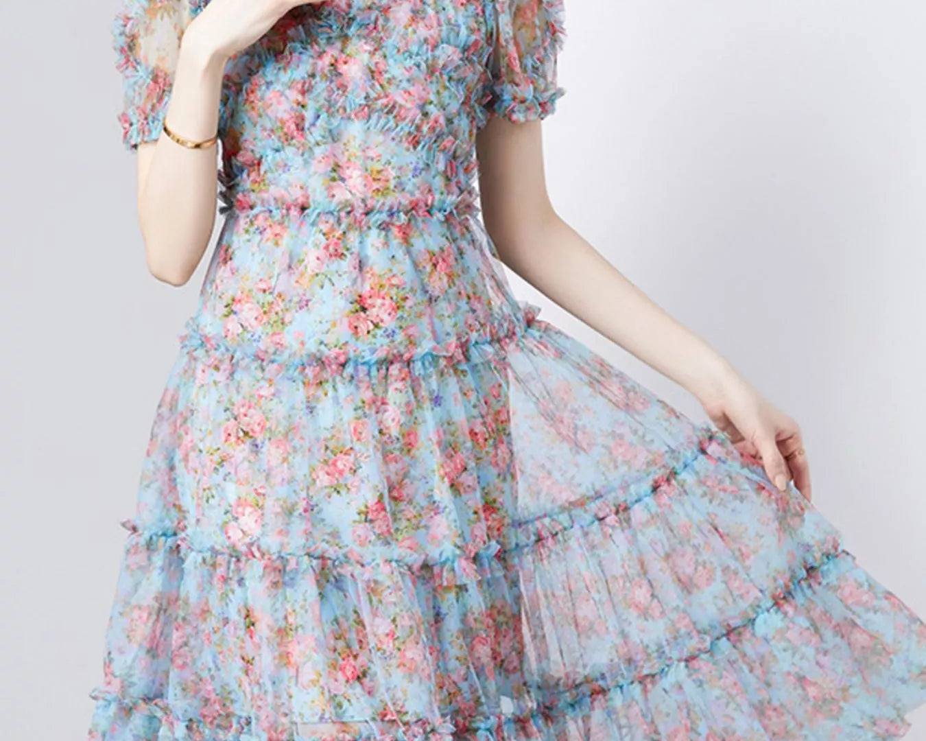 NEWYORKLISTED STYLE COLLECTION: Woman wearing a floral dress on a white background