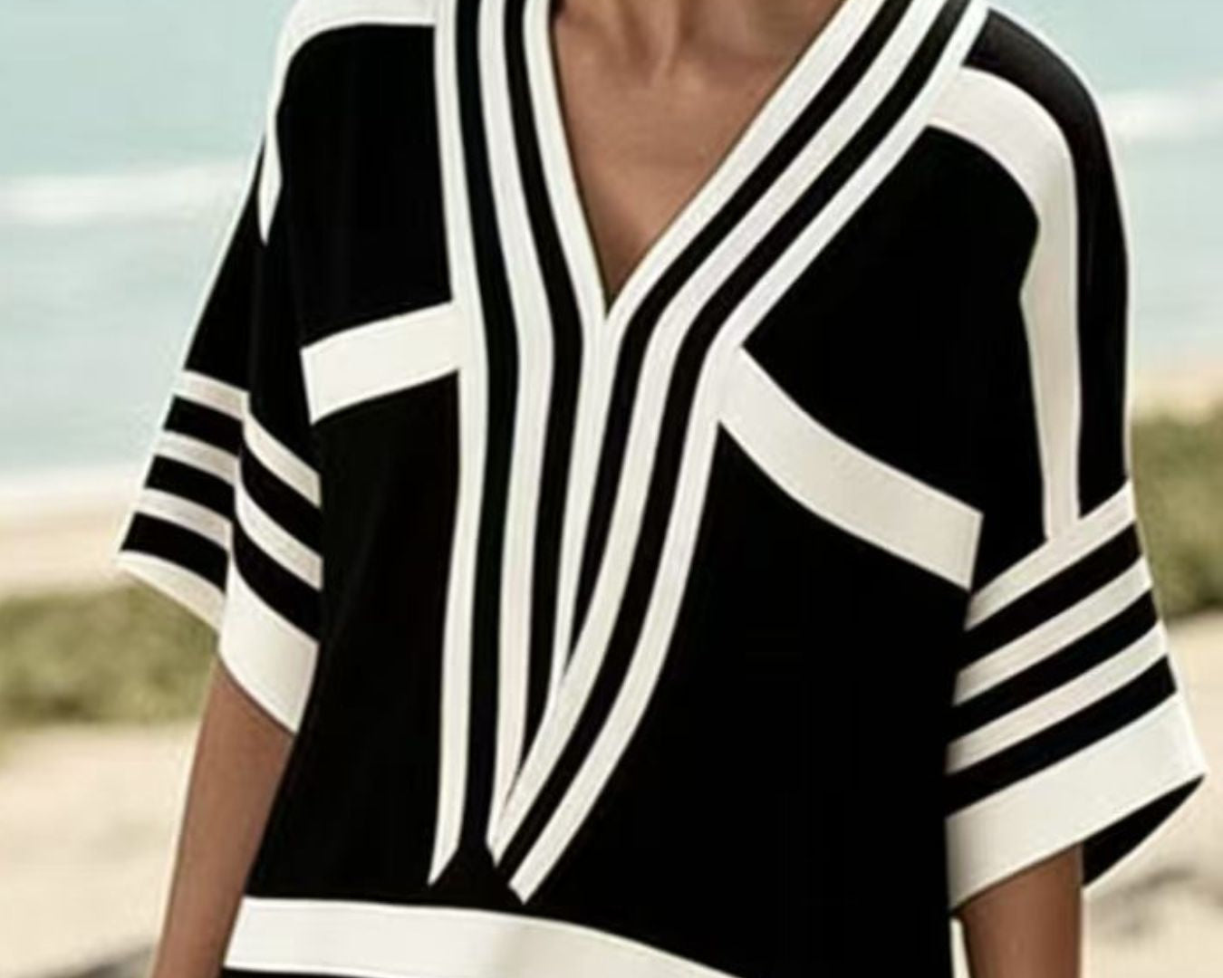 NEWYORKLISTED STYLE COLLECTION: Woman wearing a black and white striped cover-up on a beach.