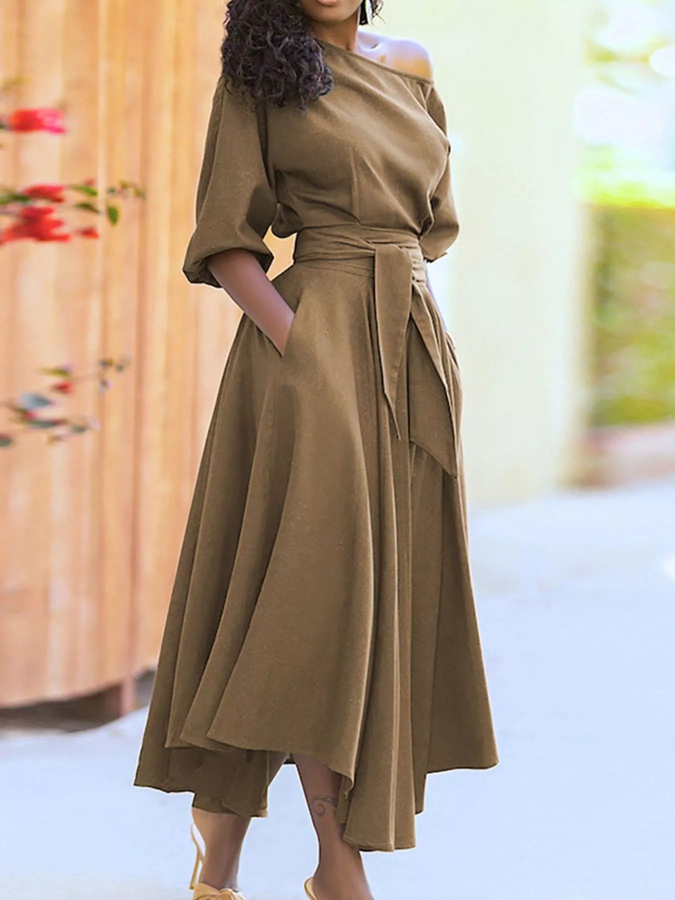 NEWYORKLISTED STYLE COLLECTION: Woman wearing a brown dress with a blurred background