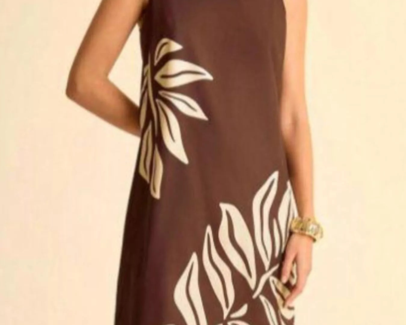 NEWYORKLISTED STYLE COLLECTION: Brown dress with leaf pattern worn by a person on a beige background