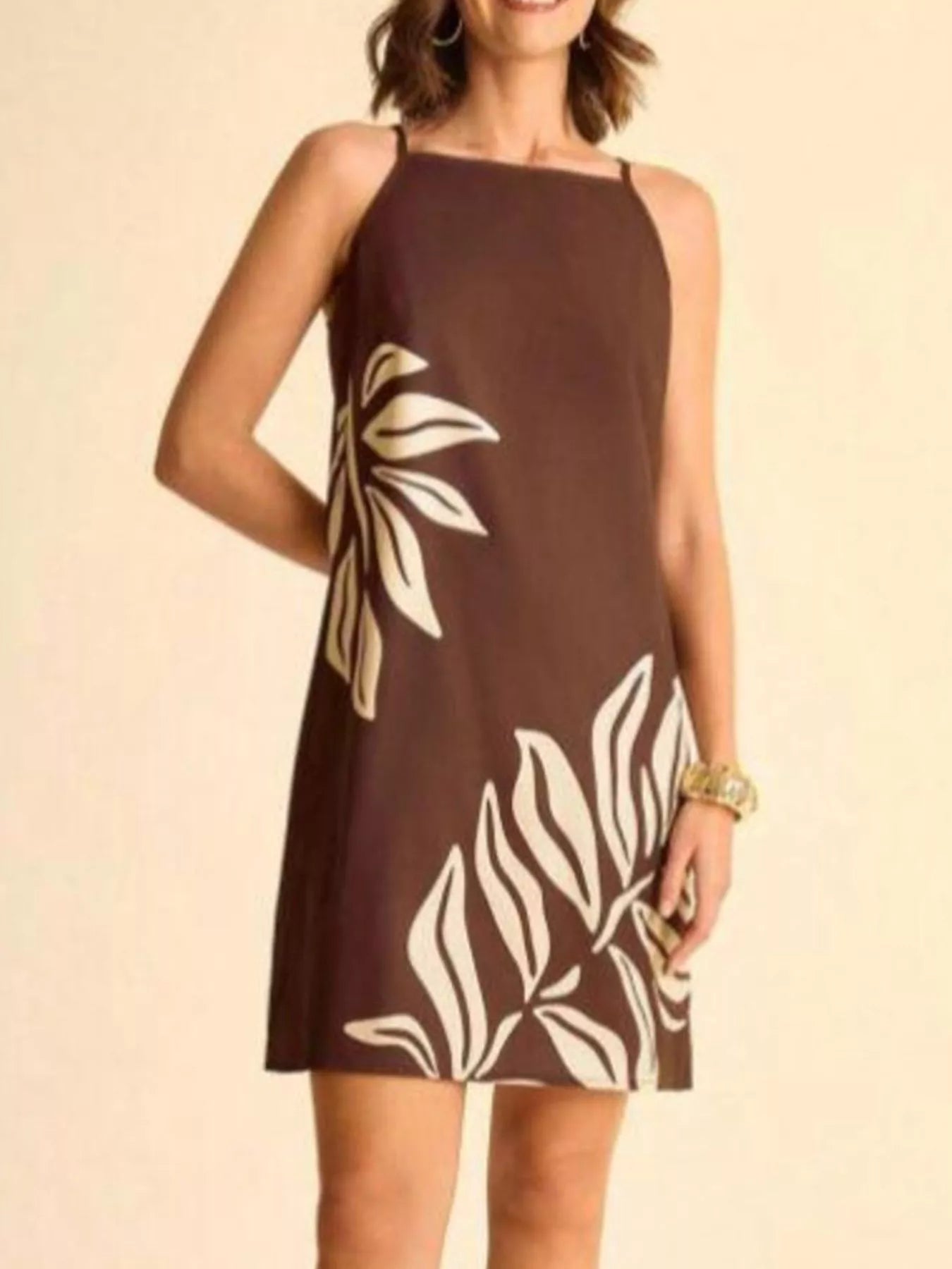 NEWYORKLISTED STYLE COLLECTION: Brown dress with leaf pattern worn by a person on a beige background