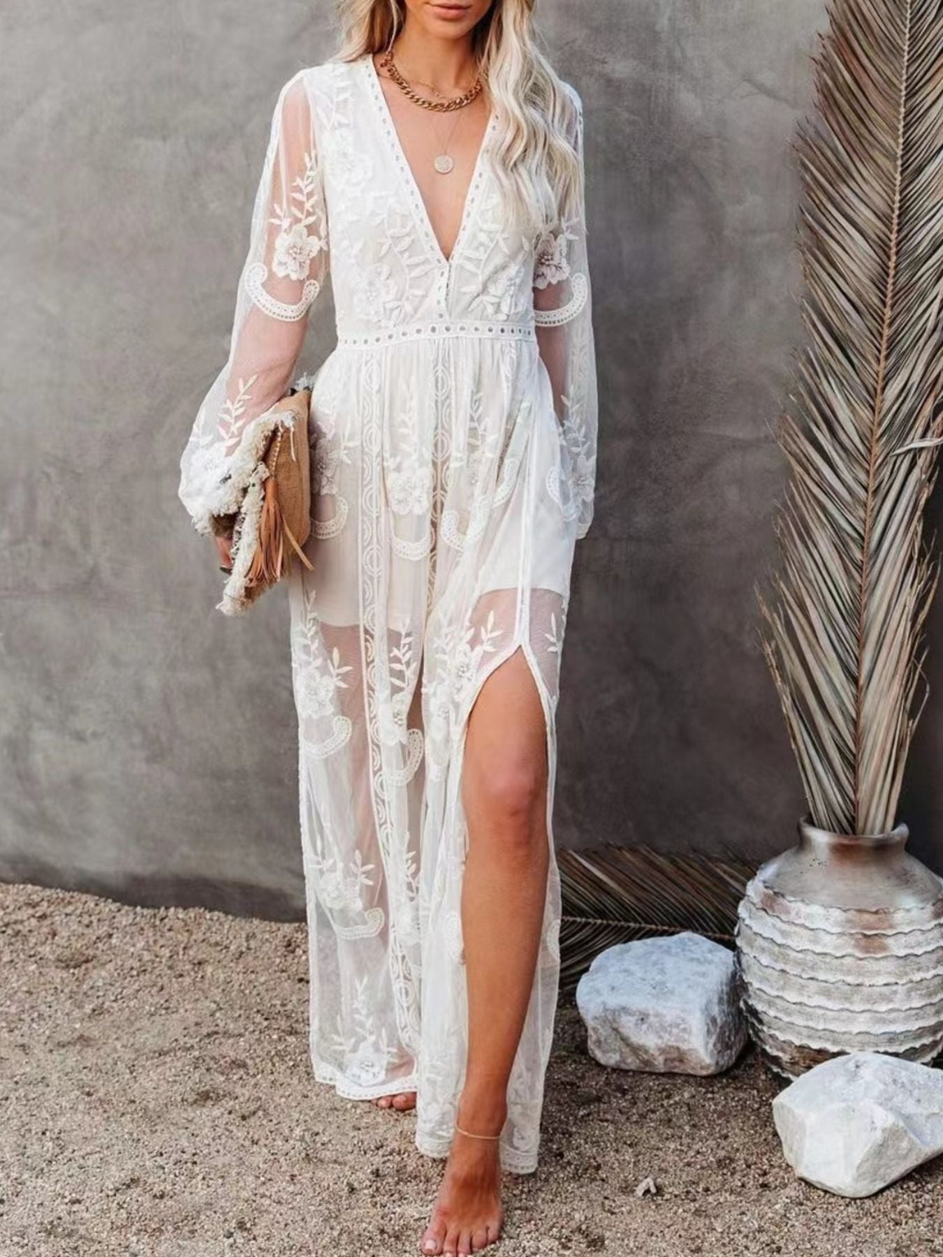 NEWYORKLISTED STYLE COLLECTION: Woman wearing a white lace dress with a slit, standing against a neutral background.