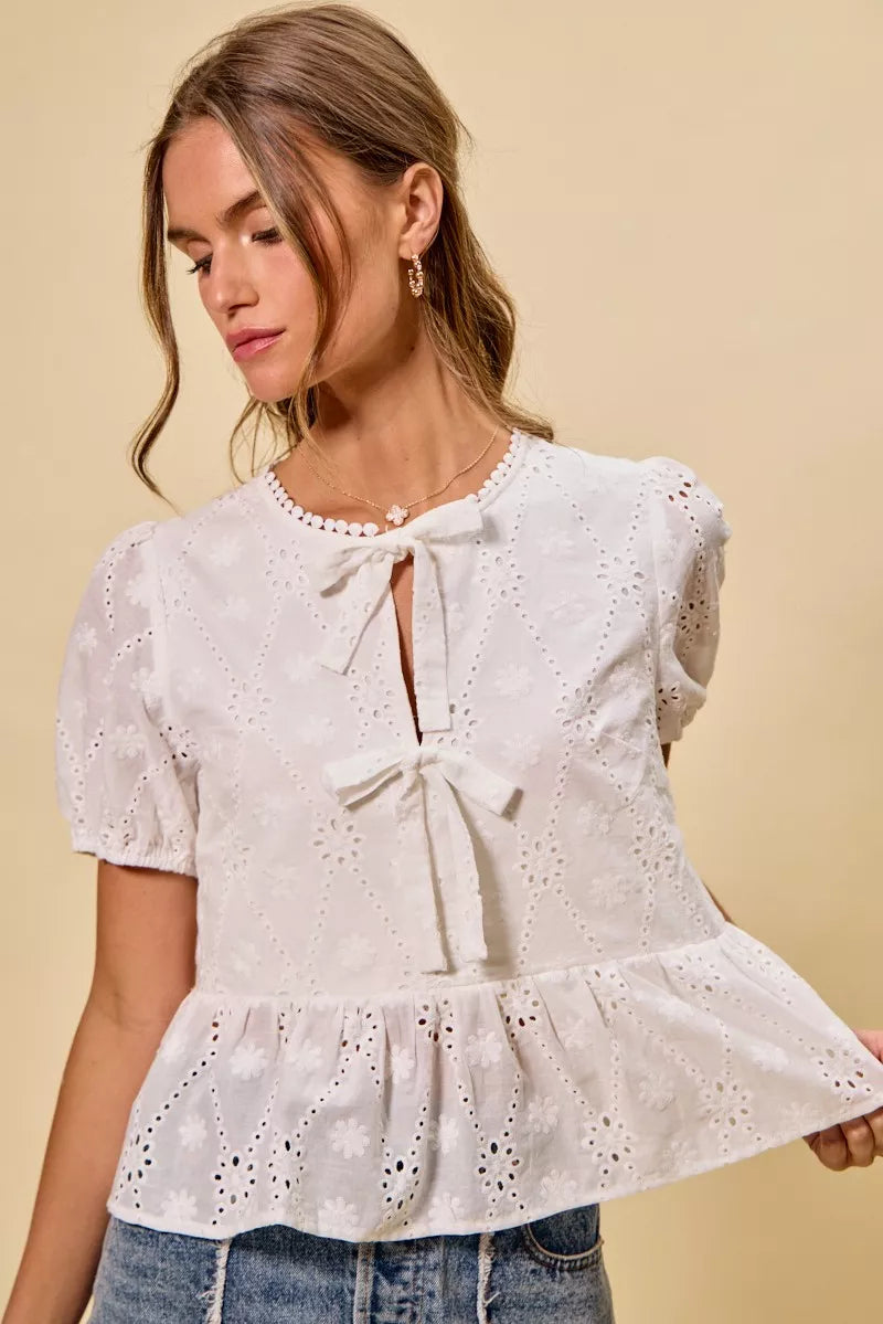 NEWYORKLISTED STYLE COLLECTION: Woman wearing a white lace top with a beige background