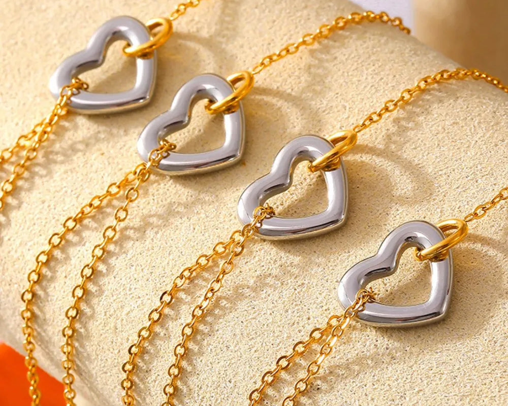 NEWYORKLISTED Valentine's Day Specials: Gold and silver heart-shaped necklace on a beige surface