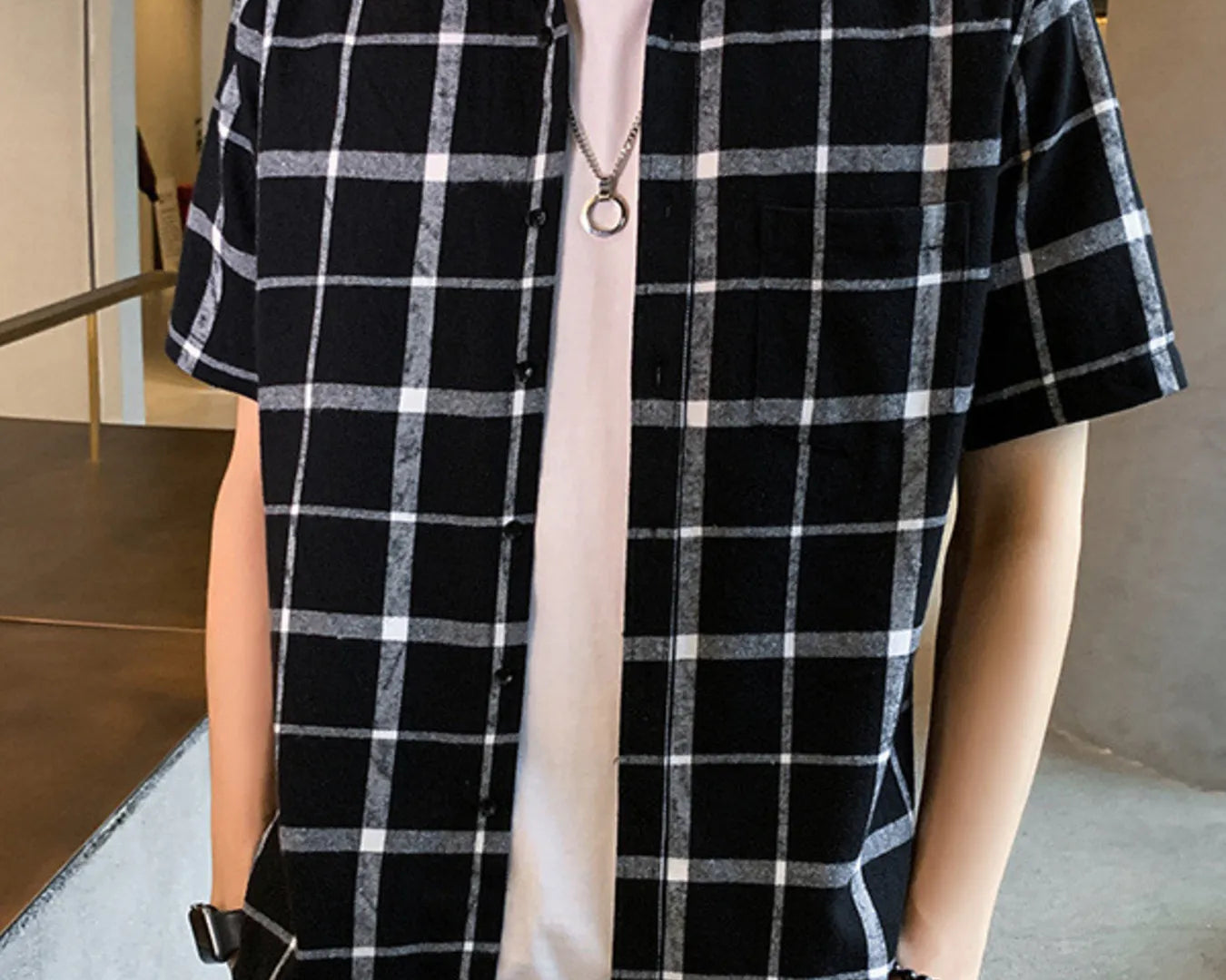 NEWYORKLISTED ATLAS MEN'S COLLECTION: Person wearing a black and white checkered shirt with a plain background