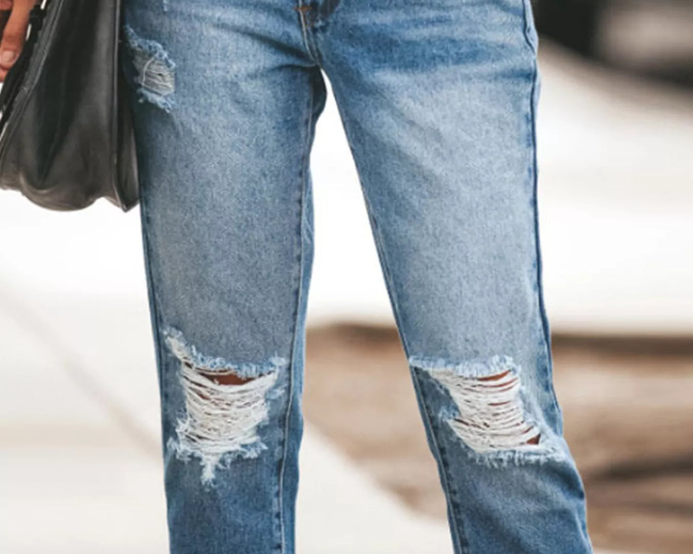 NEWYORKLISTED STYLE COLLECTION: Ripped blue jeans worn by a person with a blurred background
