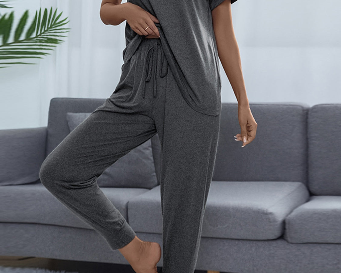 NEWYORKLISTED Intimate Apparel: Person wearing a gray pajama set in a living room.